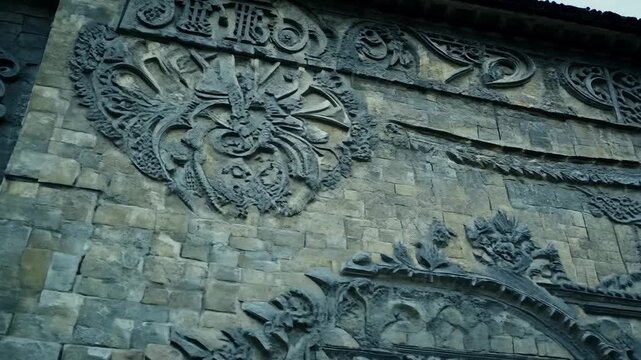 An old stone building with intricate carvings and ornate architectural details on its weathered facade. 4k Video footage