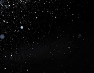 Obraz premium Dynamic shot of water droplets in mid-air against a black background, capturing movement and light reflection, creating a minimalist, dramatic effect