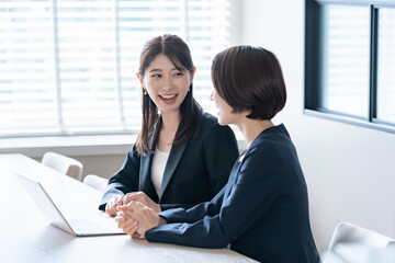 打ち合わせをするスーツを着た女性二人