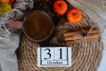 Halloween themed still life with pumpkins, rustic rope, and October 31 wooden block calendar for...