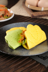 Traditional Handmade Asian Steamed Buns with Shredded Pork Filling on Black Plate