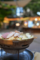 Thai barbecue grill pork on brass pan. Selective focus and against bokeh background