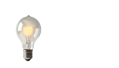 Illuminated incandescent light bulb against black background