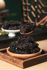 Black Dried Jujubes from Xinjiang China in Wooden Bowl Traditional Chinese Fruit Snack