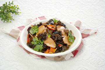 Close-up of fried ham sausage with black fungus, cloth pattern background