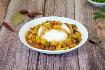 Rice topped with potato on wooden table, star anise, pepper. Close-up
