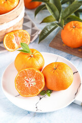 Fresh Gannan Tangerines and Citrus Fruits on White Marble Plate with Green Leaves