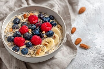 Colorful smoothie bowl with banana, raspberries, blueberries, almonds and chia seeds. Concept: healthy eating, balanced diet, wellness trend.