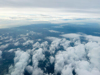 Aerial view of clouds over land and ocean seen from high altitude