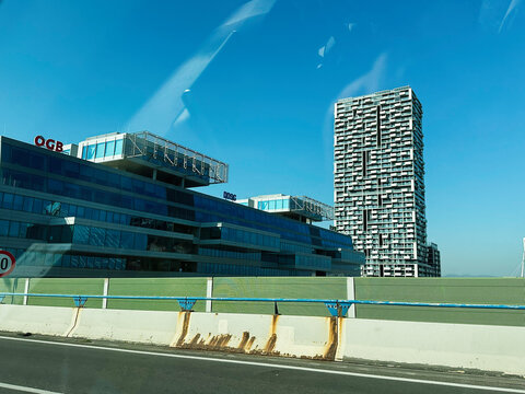 Modern office complex and tall residential Marina Tower under a clear blue sky with highway barriers in Vienna, Austria. Austrian Trade Union Federation