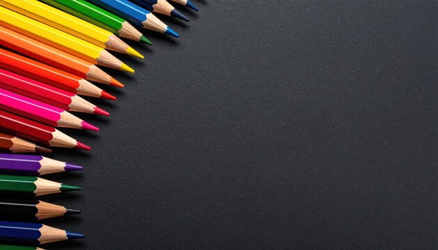 Rainbow of colored pencils arranged diagonally on black background, leaving ample space for text or graphics, close-up shot