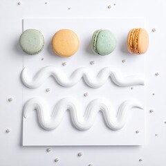 Four colorful macarons, arranged on a white square plate with swirled white frosting