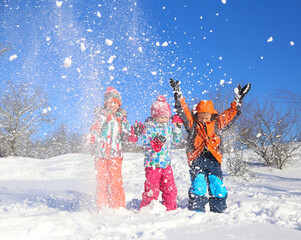 Group of children playing on snow in winter time