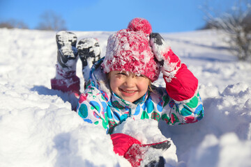 little girl  playing on snow in winter time