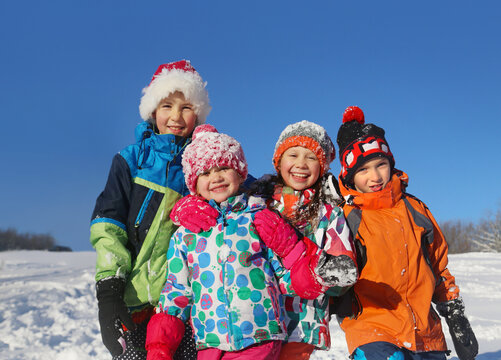Group of children playing on snow in winter time
