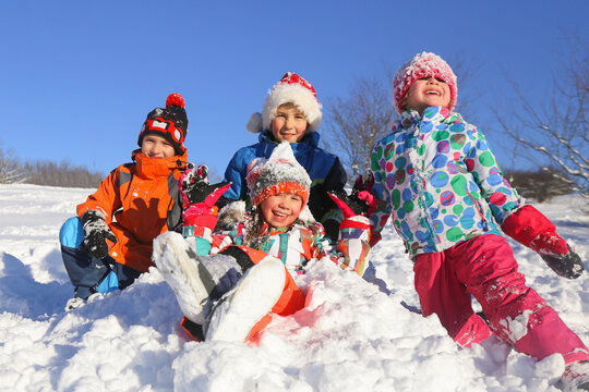 Group of children playing on snow in winter time