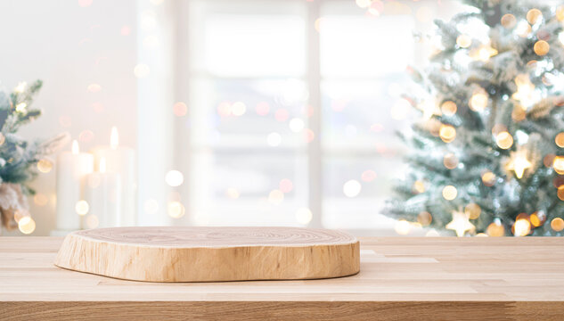 Christmas podium on wooden table for product presentation in front of festive blurred holiday decorations background