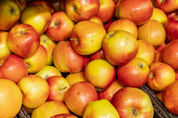 Red apples on display at bright grocery store aisle. Closeup shot of fresh red and yellow apples