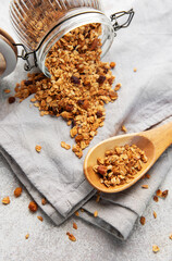 Granola pouring from jar on light background