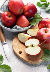 Red apples, whole and sliced, on cutting board