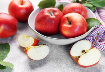 Red apples in bowl with slices on table