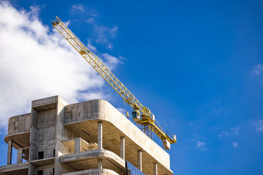 High rise building under construction in evening sky. The construction and tower crane at sunlight for the background