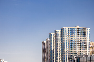 Fototapeta premium Front view of a white modern skyscraper perfect symmetry with blue sky and copy space. Architecture background concept