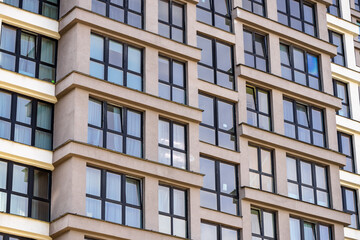 Part of Modern residential apartment with flat building exterior. Detail of New luxury house and home complex. Fragment of City Real estate property and condo architecture. Copy space. Blue sky