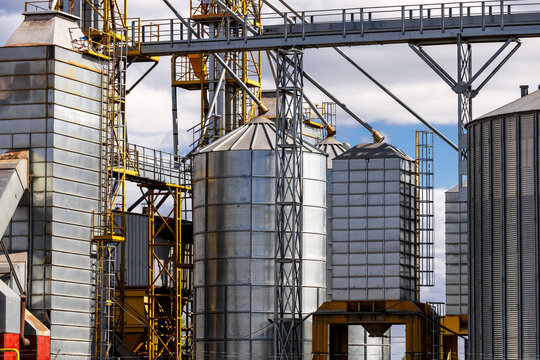 Construction of a feed mill agro-processing plant for processing and silos for drying cleaning and storage of agricultural products, flour, cereals and grain. Silver tanks close-up.
