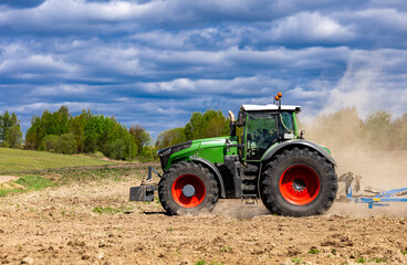 Obraz premium Agricultural plows are plowed to wait for the farming season. Farmer with tractor seeding.