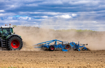 Obraz premium Agricultural plows are plowed to wait for the farming season. Farmer with tractor seeding.
