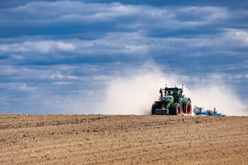 Obraz premium Agricultural plows are plowed to wait for the farming season. Farmer with tractor seeding.