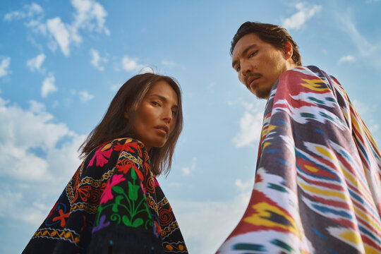 Fashion portrait of couple in traditional chapan and kaftan outdoors
