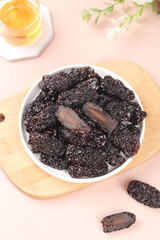 Dried Jujube Fruits in White Bowl on Light Background with Tea - Healthy Natural Snack Food...