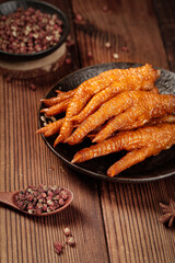 Traditional Asian Marinated Chicken Feet Snacks with Spices on Rustic Wood Background