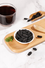 Dried Black Mulberries from Xinjiang with Tea - Healthy Superfood Snack on Wooden Board
