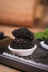 Large Dried Mulberry Fruits in White Bowl on Wooden Board - Healthy Superfood Snack Close-up