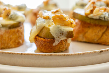 crispy crostini topped with fresh pear slices and creamy blue cheese. Perfect for illustrating elegant fall appetizers, holiday party snacks
