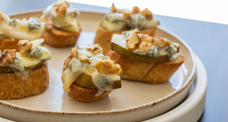 crispy crostini topped with fresh pear slices and creamy blue cheese. Perfect for illustrating elegant fall appetizers, holiday party snacks