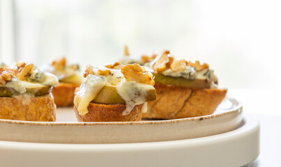 crispy crostini topped with fresh pear slices and creamy blue cheese. Perfect for illustrating elegant fall appetizers, holiday party snacks