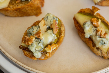 crispy crostini topped with fresh pear slices and creamy blue cheese. Perfect for illustrating elegant fall appetizers, holiday party snacks