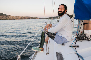 Man with prosthetic leg enjoying sailing on boat