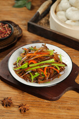 Asian stir-fried shredded vegetables with pickled radish and soy sauce lunch dish on wooden table