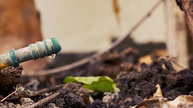 Water Dripping from Broken Hose on Soil