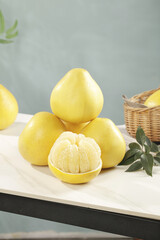 Fresh Yellow Pomelo Citrus Fruits with Sweet Segments on White Kitchen Counter