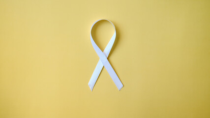 Lung Cancer Awareness Month white ribbon on yellow background