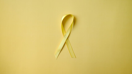 Suicide Prevention Awareness Month yellow ribbon on yellow background