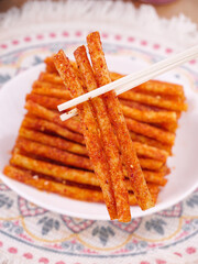 Spicy Chili Flavored Crispy Snack Sticks with Chopsticks on Traditional Plate