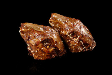 Shuangliu Marinated Rabbit Head Chinese Cold Snack with Sesame Seeds on Black Background
