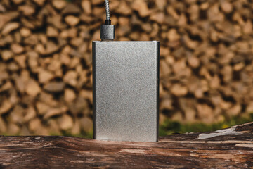 Silver Titanium and external battery on wooden surface outdoors.